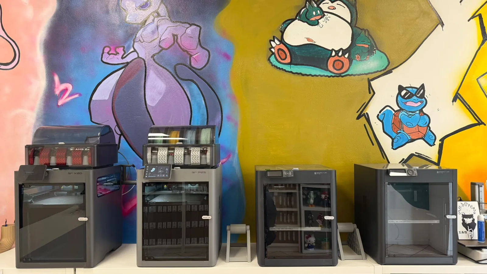 Quattro stampanti 3D Bambu Lab davanti al murales nell'Hub Lovabyte